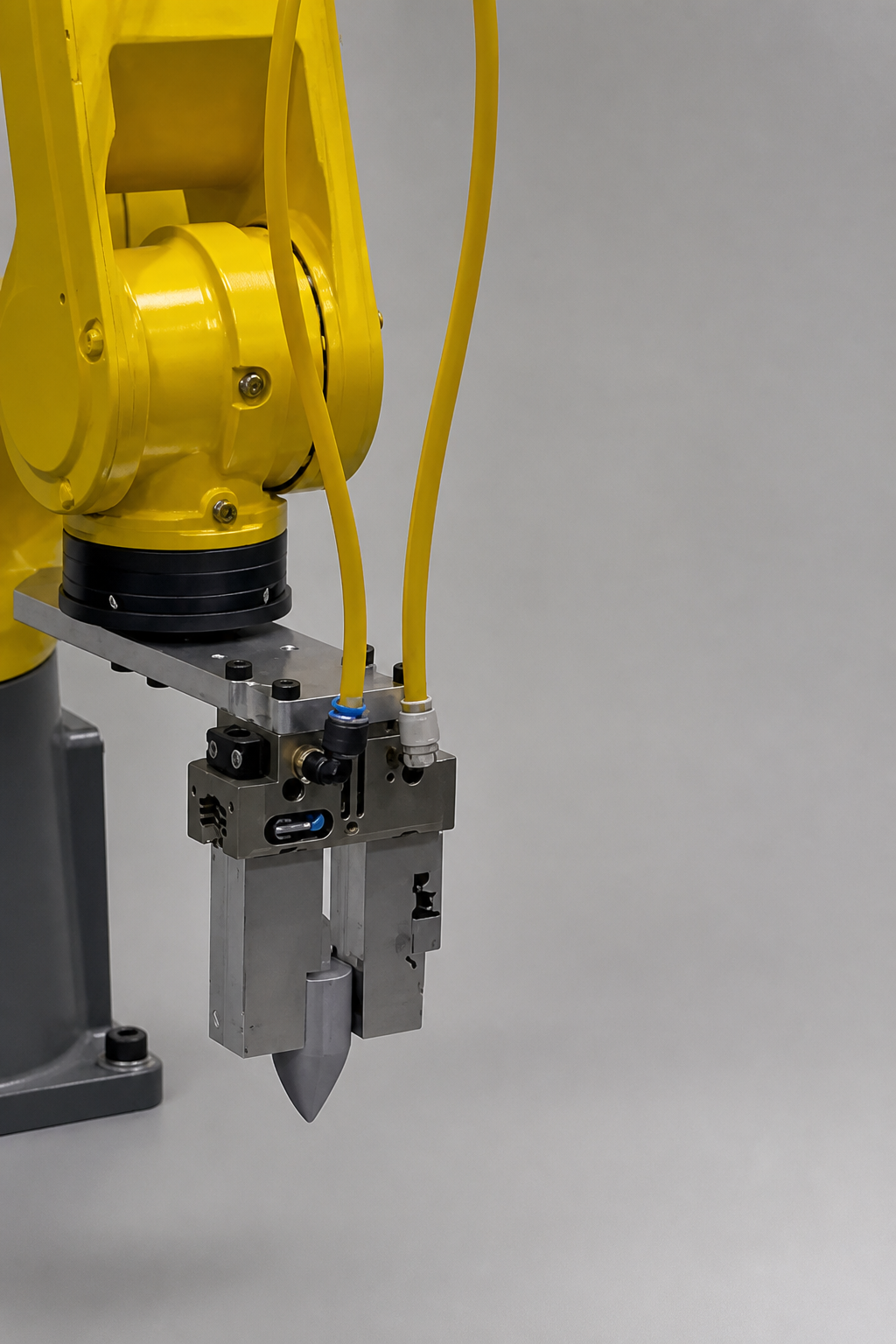 Yellow industrial robot gripper holding a small machined part